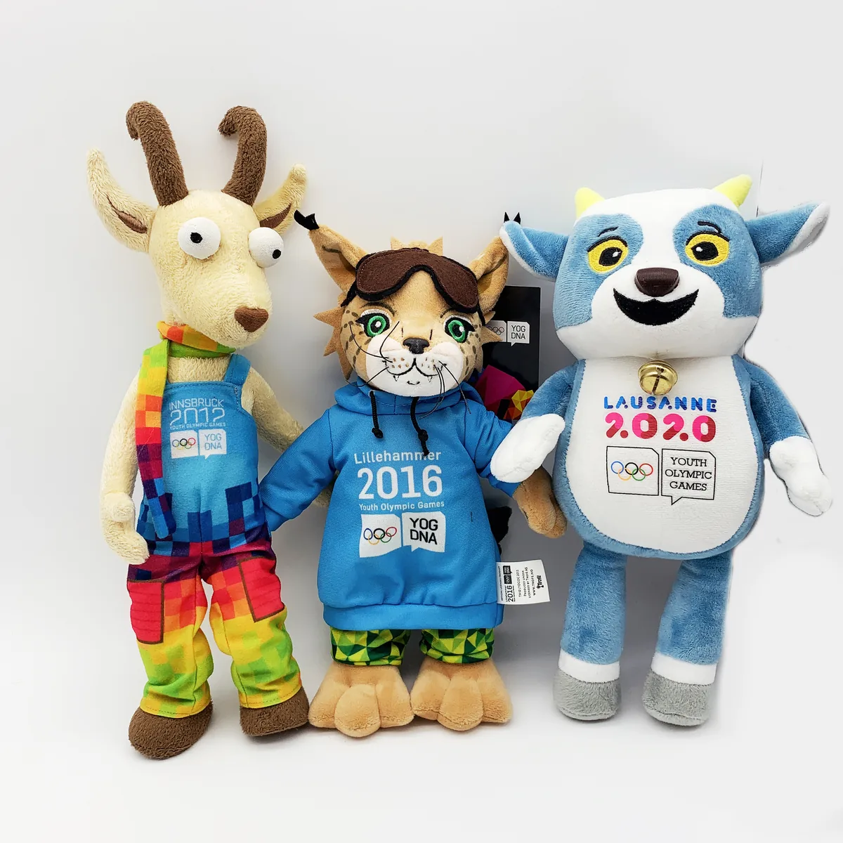 Die drei offiziellen Maskottchen der Olympischen Jugendspiele Innsbruck 2012, Lillehammer 2016 und Lausanne 2020 als Plüschfiguren mit Olympia-Ringen und Lizenz-Etikett