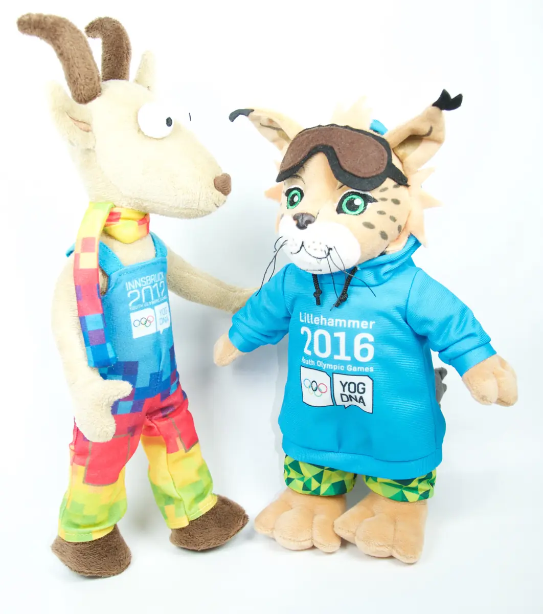 Die fertigen Plüschfiguren Yoggl (Gams, Innsbruck 2012) und Sjogg (Luchs, Lillehammer 2016) mit YOG-Logo auf der Kleidung