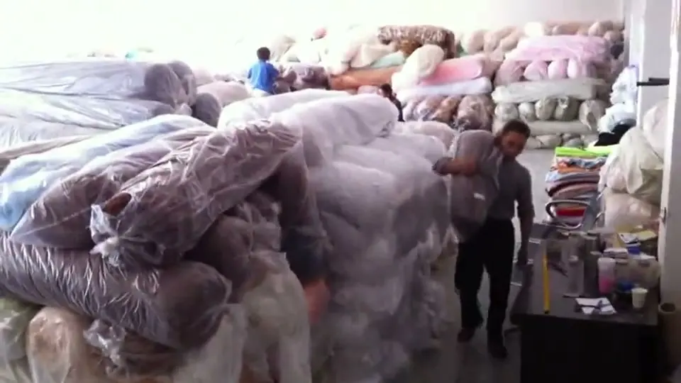 Materiallager der Lindner-Manufaktur: Ballen mit Plüschstoff, Mitarbeiter beim Kommissionieren